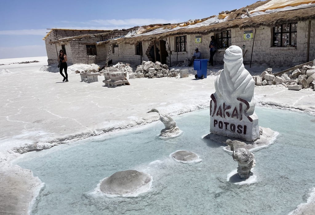 Das Salzhotel Playa Blanca liegt mitten in der Salar de Uyuni. Eine Stele erinnert daran, dass hier auch mal die Rallye Dakar Station machte.