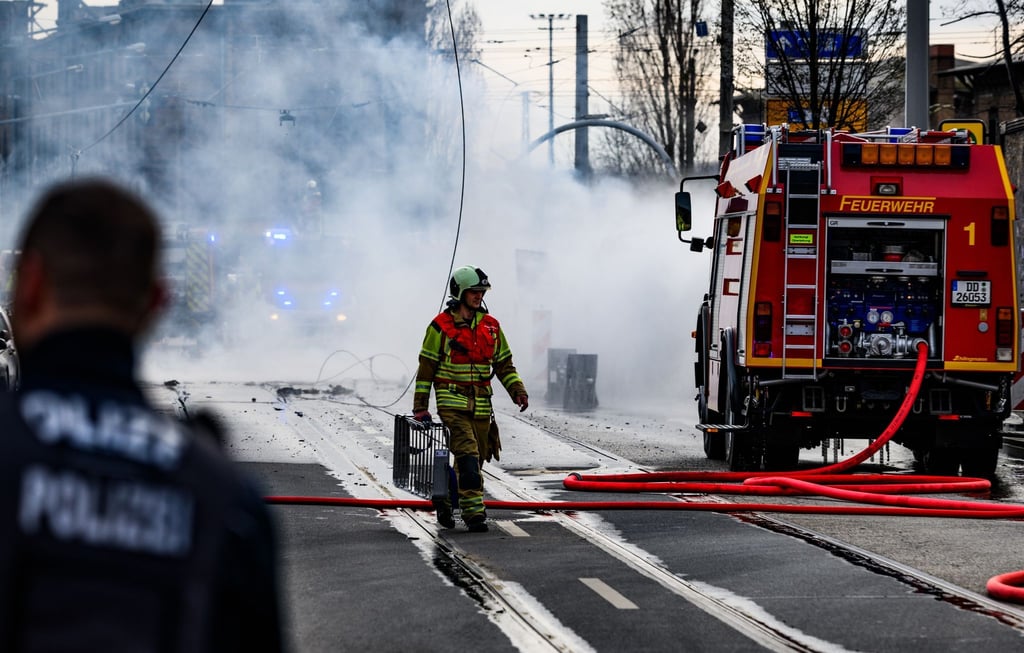 Ein Feuerwehrmann geht während des Einsatzes rund um eine Gasexplosion in der Friedrichstadt über die Straße.