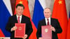 Chinas Präsident Xi Jinping und sein russischer Amtskollege Wladimir Putin zeigen während einer Unterzeichnungszeremonie Mappen mit den neuen Abkommen.