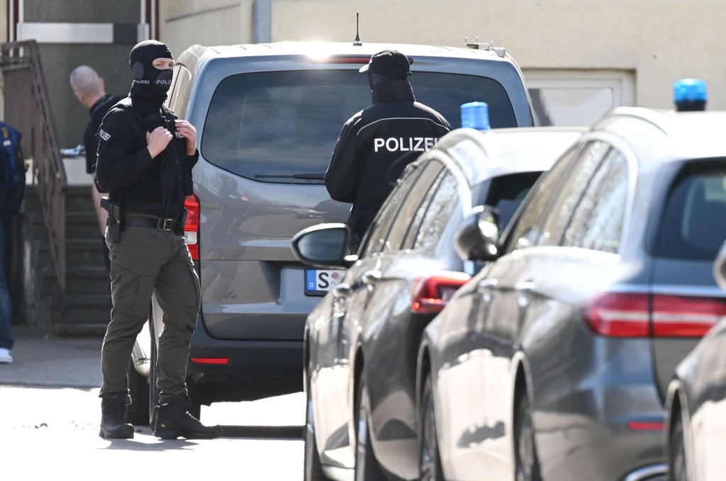 Einsatzkräfte stehen an Einsatzfahrzeugen.