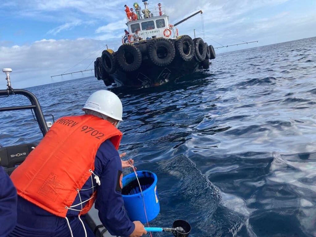 Ein Mitarbeiter der Küstenwache übernimmt Wasserproben, nachdem ein vor der Küste der Philippinen gesunkener Tanker Öl verloren hat.