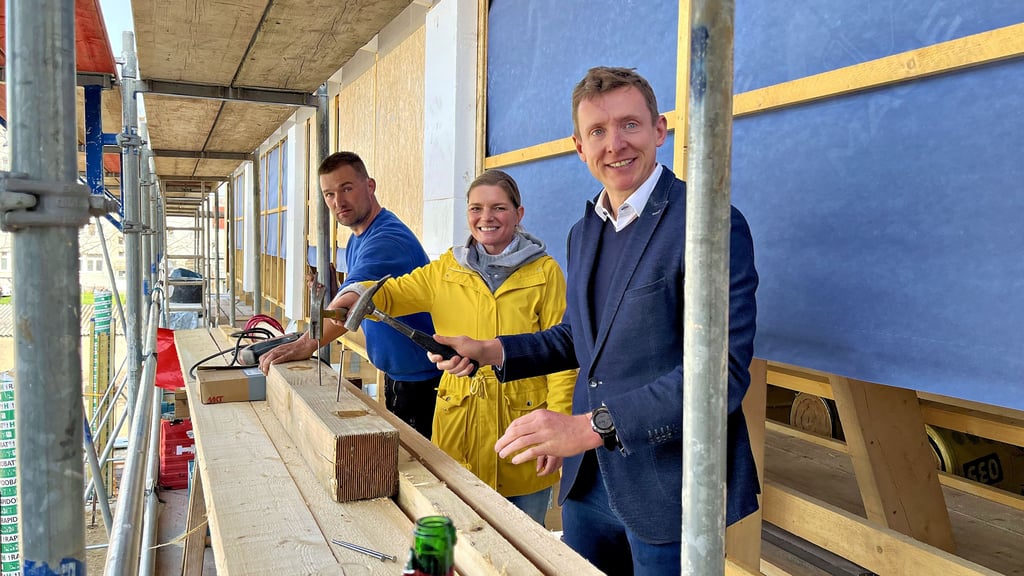 Richtfest bei Norma in Tangerhütte: Dachdecker Marcel Leo verlas den Richtspruch, während Norma-Entwicklungsleiterin Jennifer Gores und Tangerhüttes Bürgermeister Andreas Brohm (rechts) die Richtnägel einschlugen.