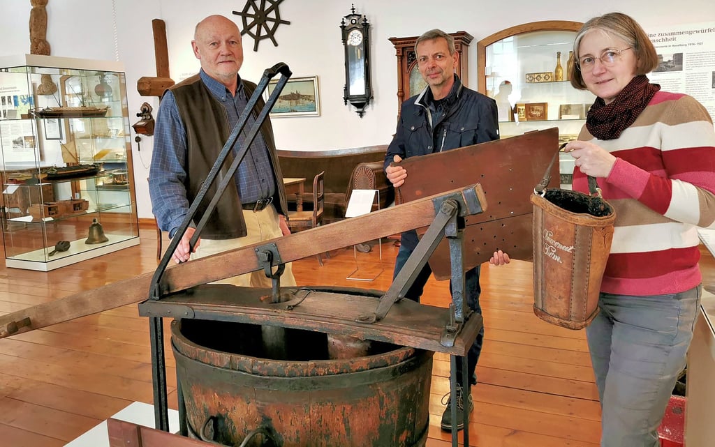 Fördervereinsvorsitzender Harald Wildhagen, Restaurator Jens Zimmermann und Museumsleiterin Antje Reichel (von links) freuen sich, dass die frisch restaurierte Handdruckspritze wieder im Prignitz-Museum steht.