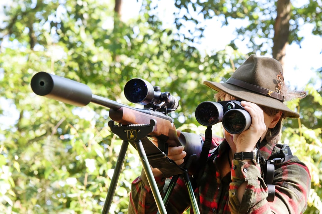 Jägerin Cynthia schaut neben ihrem Gewehr durch ein Fernrohr, bevor sie auf Jagd in ihrem Revier geht.