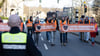 Aktivisten der Bewegung „Letzte Generation“ gehen mit Plakaten bei einem friedlichen Protestmarsch über eine Hauptverkehrsstraße.