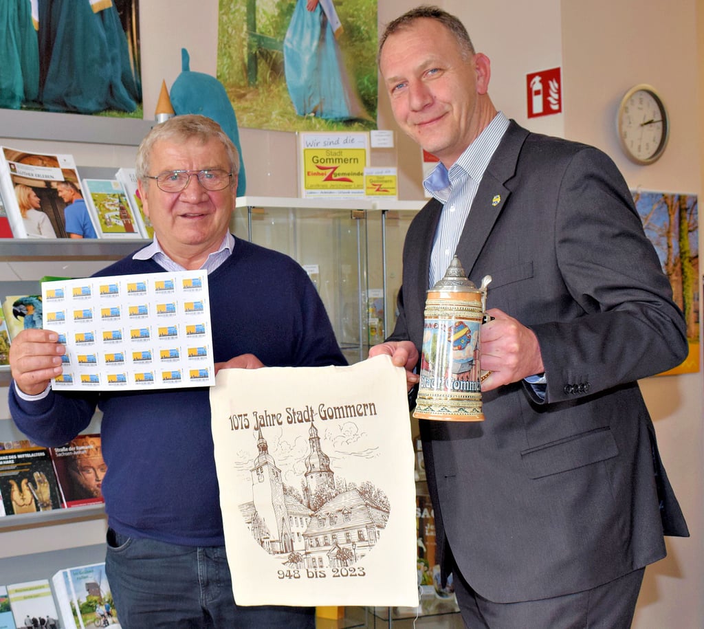 Gommern feiert in diesem Jahr 1075. Geburtstag. Zum Jubiläum hat die Biberpost eine Briefmarke mit dem offiziellen Jubiläumslogo herausgebracht. Konrad Zahn, Vorsitzender des Stadtfördervereins „Wir für Gommern", hält einen Briefmarken-Bogen in der Hand. Stoffbeutel und den Bierkrug, die Bürgermeister Jens Hünerbein in den Händen hält, sind zwei praktische Erinnerungsstücke an den 1075. Geburtstag, der in Gommern mit einem Veranstaltungsreigen begangen wird.