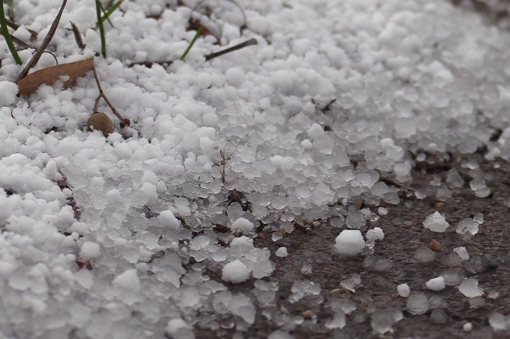 Schneekörner liegen am Wegesrand.