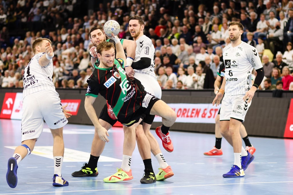Berlins Mathias Gidsel und Kiels Hendrik Pekeler kämpfen um den Ball.