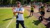 Elias Nerlich, FIFA-Streamer, steht am Spielfeldrand und klatscht.