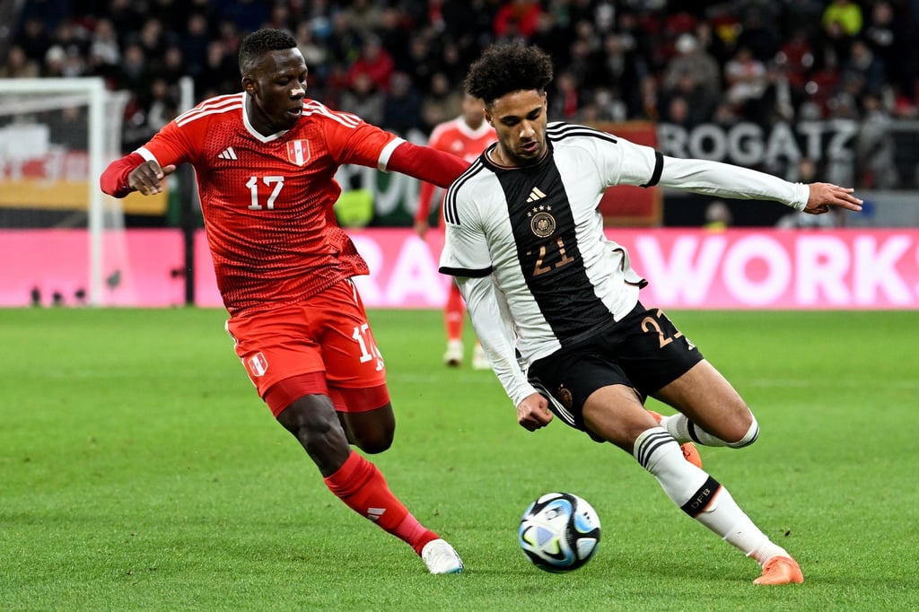 Deutschlands Kevin Schade (r) und Perus Luis Advincula kämpfen um den Ball.