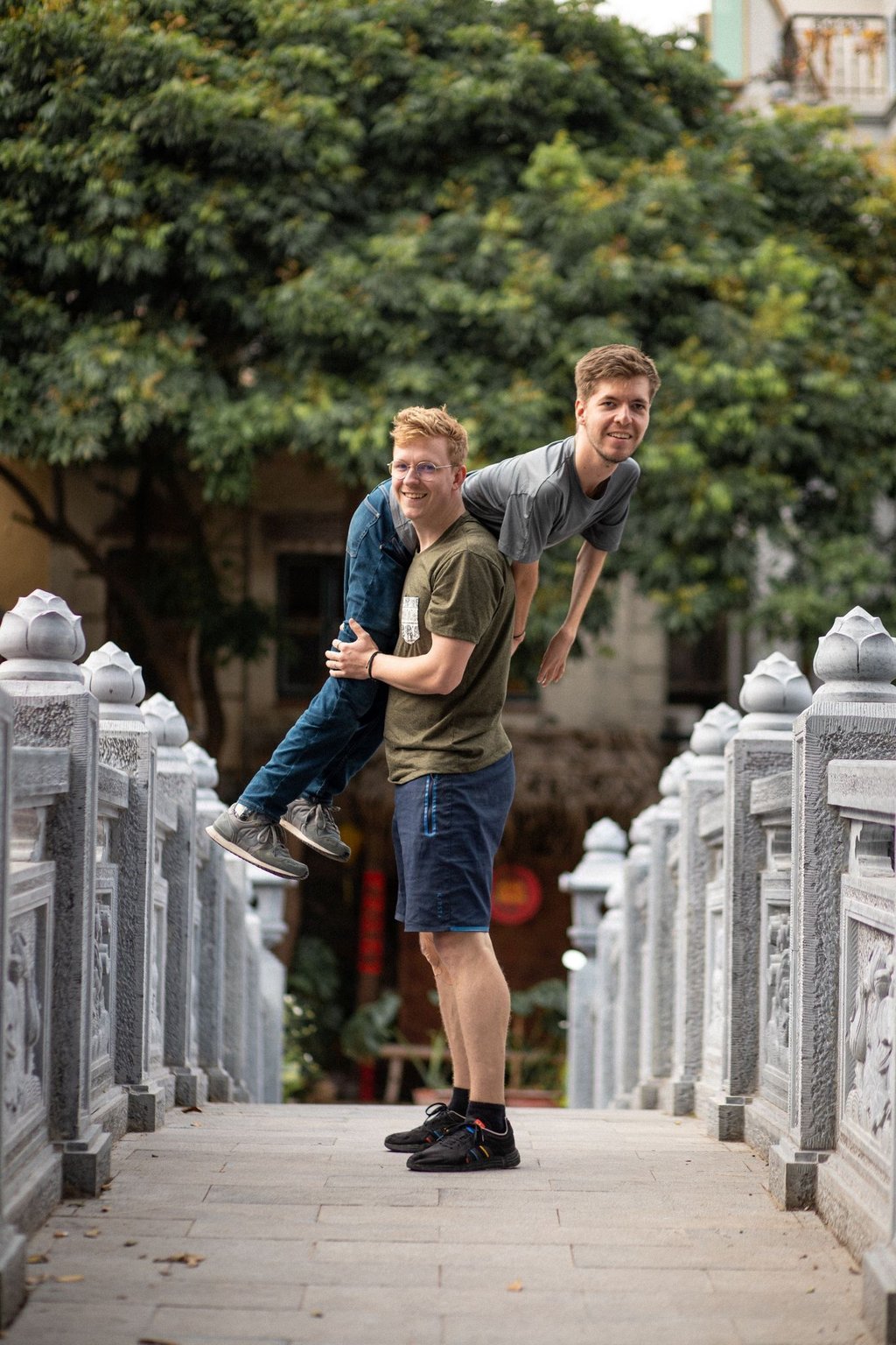 Lovis Wiefelschütz trägt seinen Freund Alexander Källner über der Schulter auf einer Brücke in Vietnam.