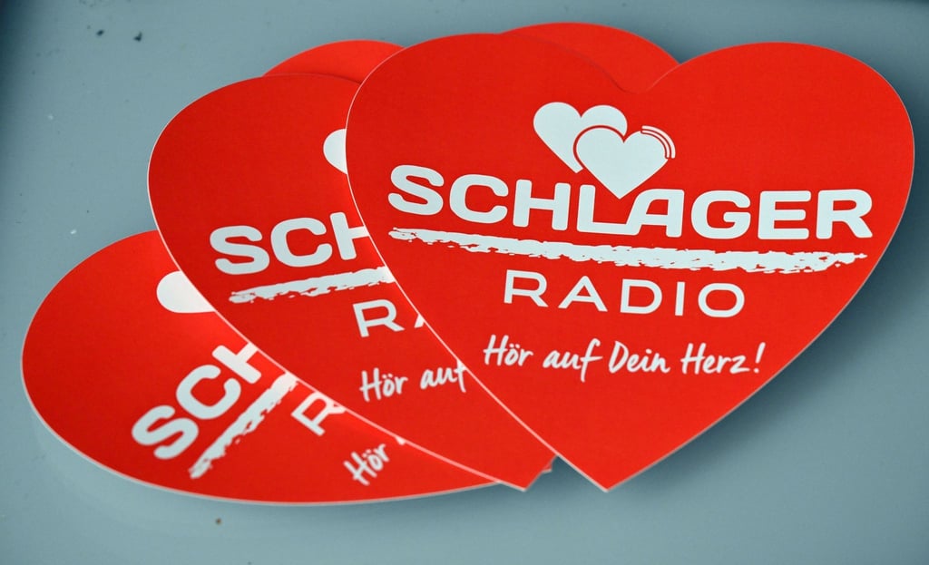 Werbemittel mit dem Aufdruck "Schlager Radio" liegen auf einem Tisch.