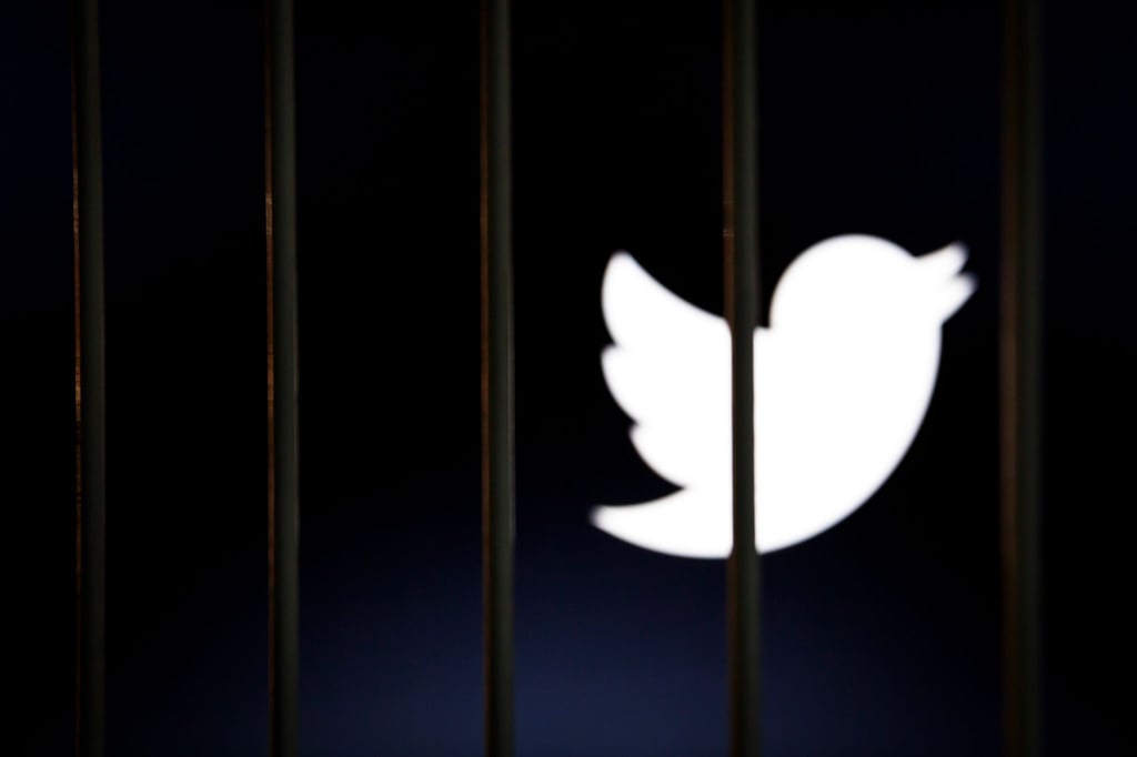 Das Twitter-Logo auf einem Bildschirm hinter Gittern.