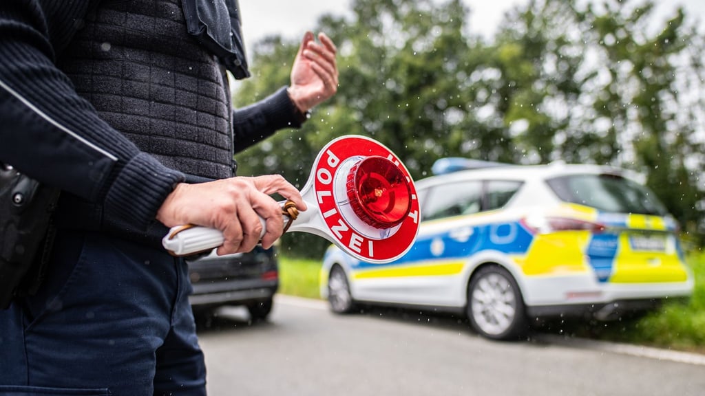 Eine Polizistin hält eine Winkerkelle in der Hand.