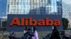 Frauen mit Mund-Nasen-Schutz gehen an den Büros des chinesischen E-Commerce-Unternehmens Alibaba vorbei.