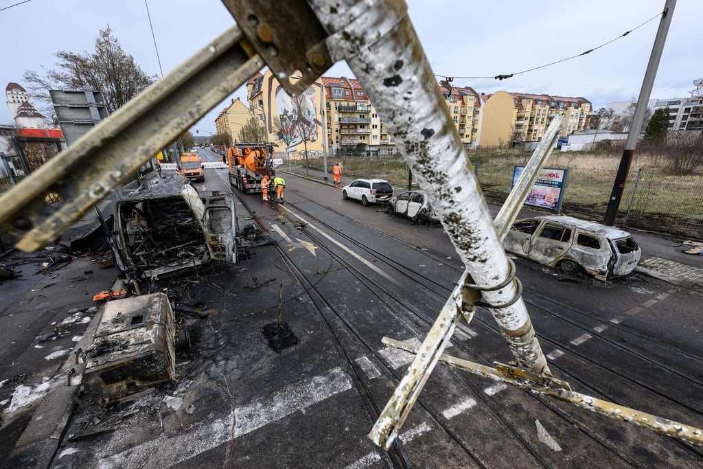 Ausgebrannte Autos stehen nach einem Brand an einer Gasleitung im Stadtteil Friedrichstadt am Straßenrand.