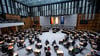 Abgeordnete stehen im Plenarsaal des Berliner Abgeordnetenhauses.