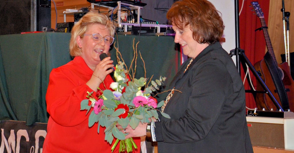 Anke Uebrig (links) vom Frauenchor Viktoria überreicht während der Dankeschönveranstaltung für die Mitwirkenden des 59. Güstener Karnevals bei Tine Kern ein Präsent.