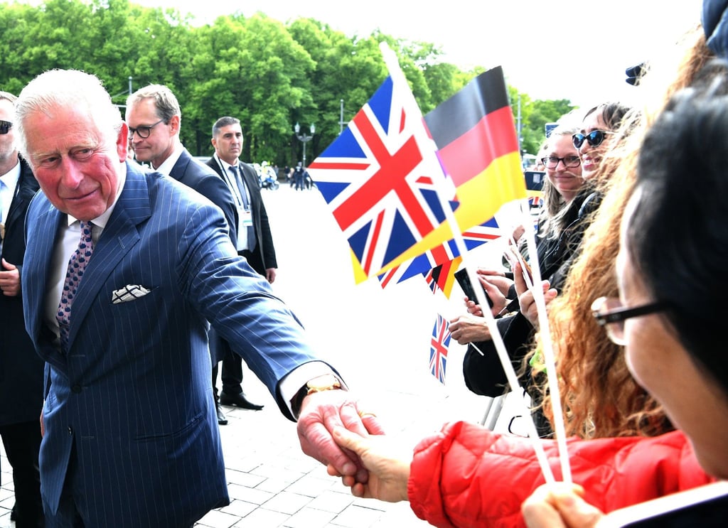 Der damalige britische Prinz Charles (vorne) spricht mit Zuschauern vor dem Brandenburger Tor.