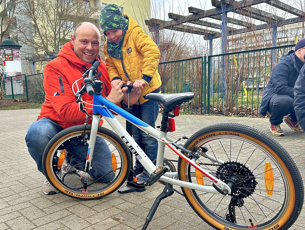 Vater Matthias Krüger und sein sechsjähriger Sohn Lennox pumpen bei der Aktionin Magdeburg-Olvenstedt gemeinsam die Reifen auf.
