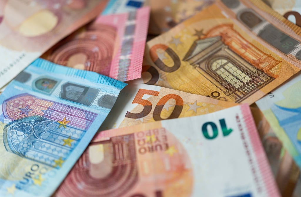 Zahlreiche Banknoten von 10, 20 und 50 Euro liegen auf einem Tisch.