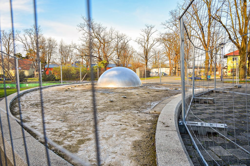 Wenn der Springbrunnen am Pechauer Platz in Betrieb ist, dann wird die silberne Kugel mit Wasser umströmt. Zudem sprudelt es aus den Fontänen ringsum.
