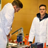 Robin Mäder (v.l.) und Niklas Krahberg arbeiten mit einer Spritzgussmaschine.