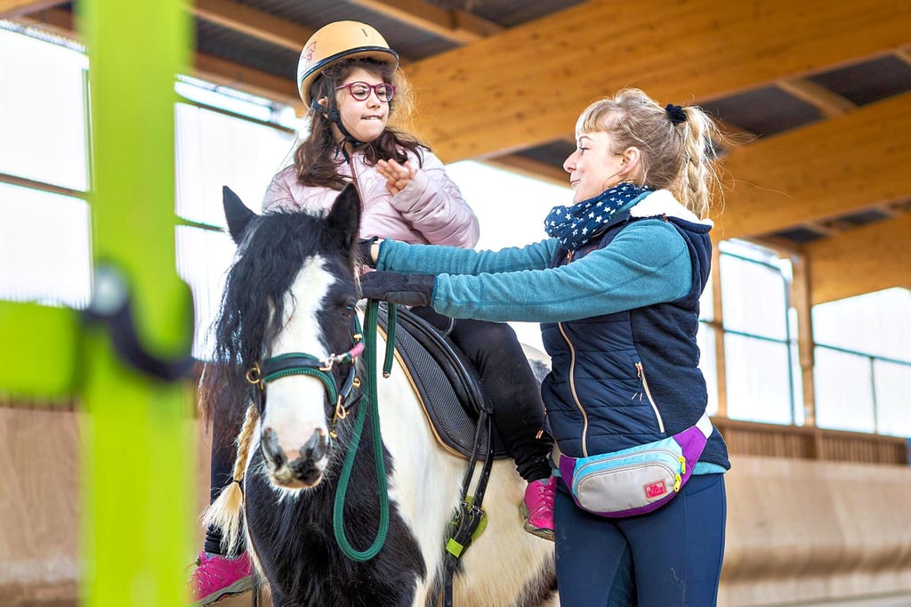 Die Reiterin ist fast blind und besucht die Johann-Traugott-Weise-Schule in Zeitz-Ost. Für sie kostet es viel Mut, sich auf das Pony Blümchen zu setzen. Reitlehrerin Sabrina Schmidtke führt Reiter und Pferd in der Halle des Zeitzer Reitvereins.