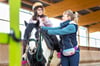 Die Reiterin ist fast blind und besucht die  Johann-Traugott-Weise-Schule in Zeitz-Ost.  Für sie kostet es viel Mut, sich auf das Pony Blümchen zu setzen.  Reitlehrerin  Sabrina Schmidtke führt Reiter und Pferd in der Halle des  Zeitzer Reitvereins. 