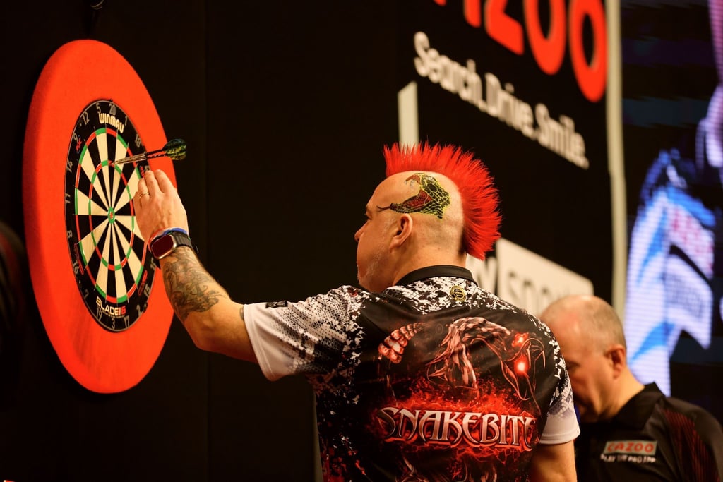 Peter Wright entfernt die Pfeile nach einem 180er-Wurf.