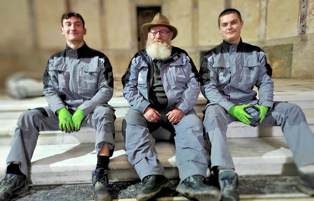 Ihren „Chef“ Klaus-Dieter Mehlhorn in die Mitte genommen haben Karl Richter (li.) und Emil Pannwitz. Sie sitzen auf der frisch polierten Mamortreppe.