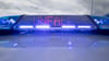 Ein Blaulicht und eine LED-Anzeige leuchten auf dem Dach eines Polizeifahrzeugs.
