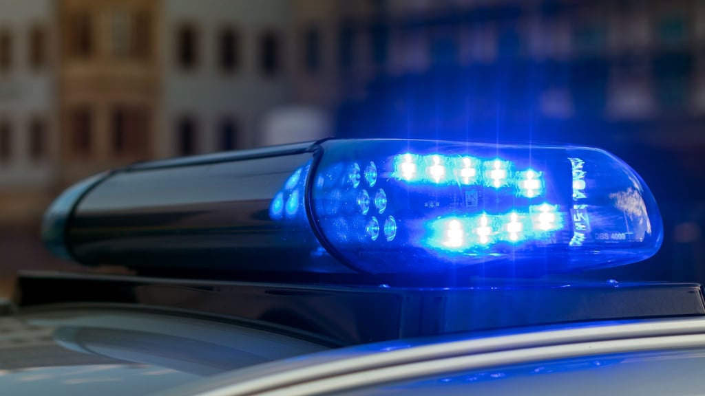 Das Blaulicht auf einem Fahrzeug der Polizei leuchtet in der Dunkelheit.