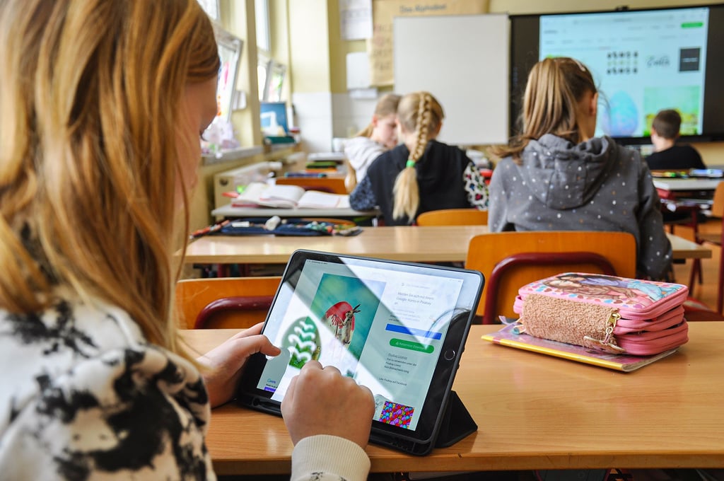 Lea (im Vordergrund) und ihre Mitschüler aus der vierten Klasse der Grundschule Flessau gestalten auf Tablets kurz vor den Ferien virtuelle Osterkarten.