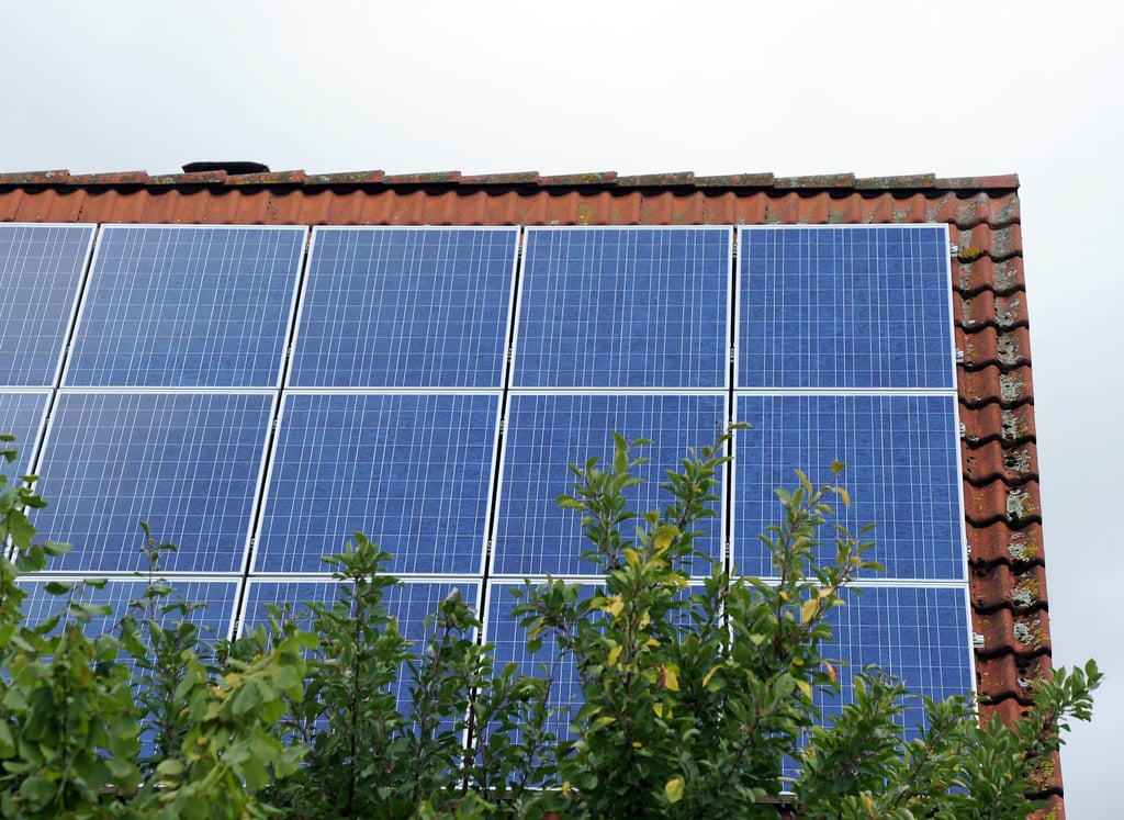 Ein Dach ist mit Photovoltaik-Modulen bestückt.
