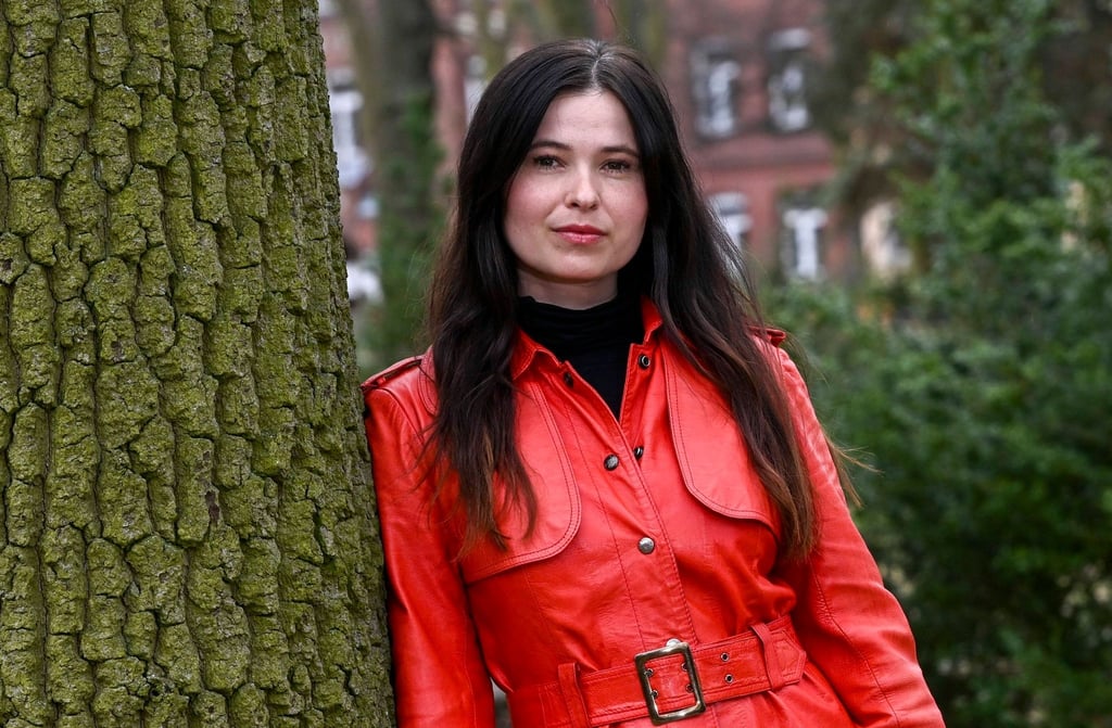 Schauspielerin Anna Fischer lehnt bei einem Fototermin an einem Baum.