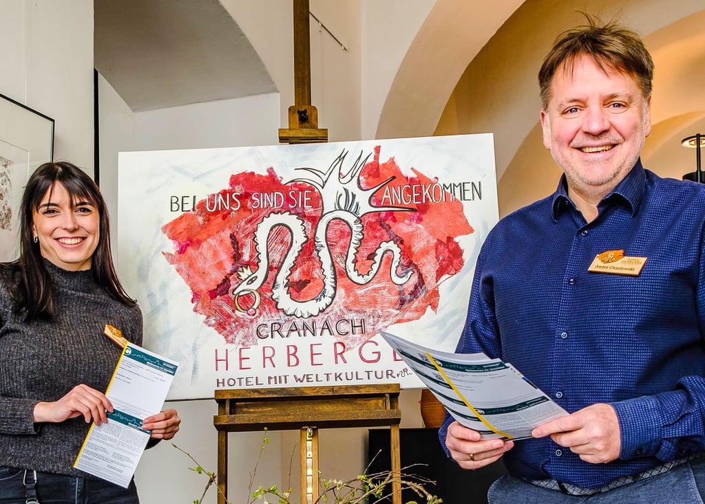 Der Leiter der Cranach-Herberge André Chmilewski und Mitarbeiterin Sophie Botta mit den Meldeformularen für den neuen Gästebeitrag