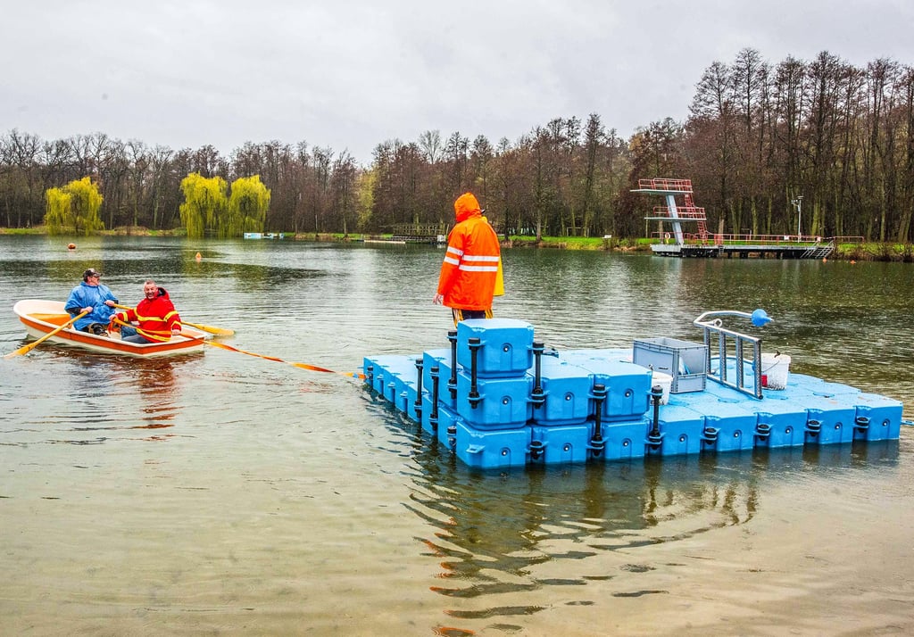 Eine der neuen Badeinseln wird zur Mitte des Sees gezogen und verankert. Dabei packt Familie Büttner selbst mit an.