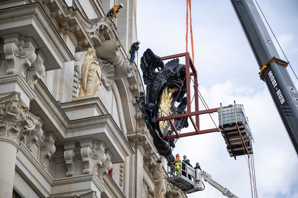 Höhenkletterer stehen bereit um die Kartusche an der Fassade des Humboldt Forums zu montieren.