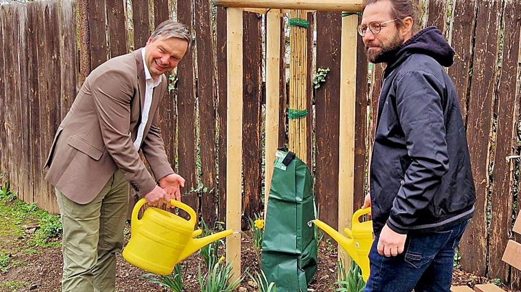 Oberbürgermeister Steffen Amme und Vereinschef Silvio Merkwitz gießen  den Baum an. 