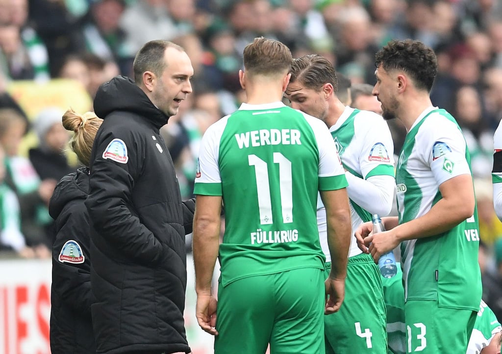 Werder Trainer Ole Werner (l) spricht während einer Unterbrechung mit Niclas Füllkrug.