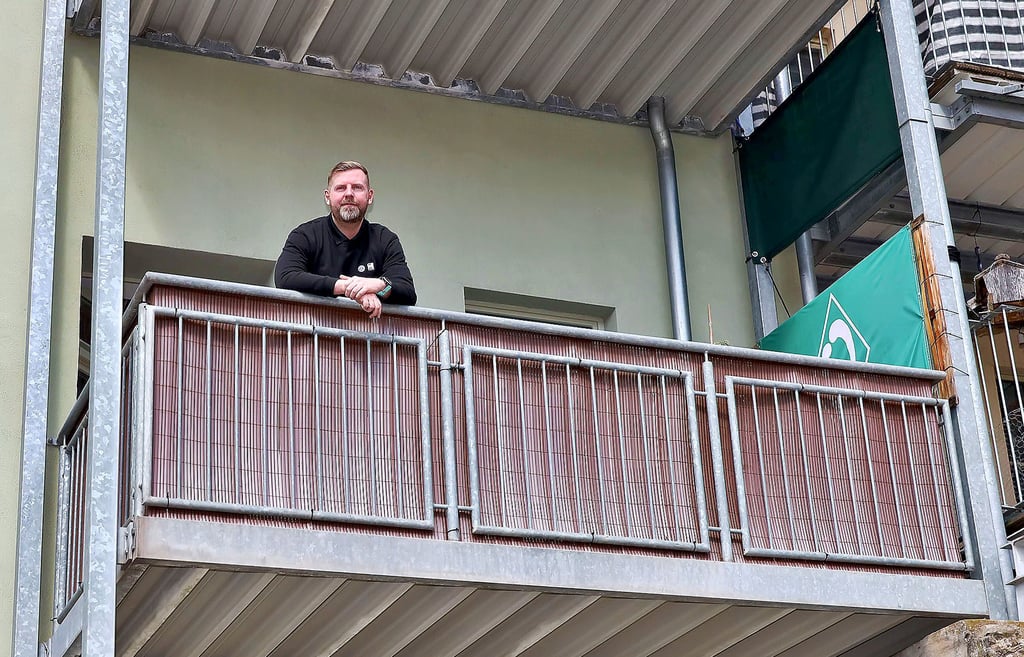 Andreas Edeler auf seinem Balkon, der zum Parkplatz Marktsüdseite zeigt. Er darf kein dort Balkonkraftwerk installieren.