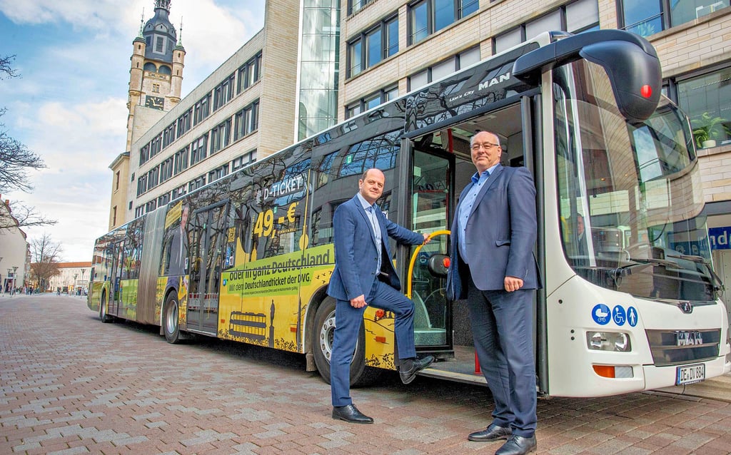 Torsten Ceglarek (r.) und Geschäftsführer Dino Höll (l.) präsentieren den beklebten Bus zum Start des Deutschlandtickets.