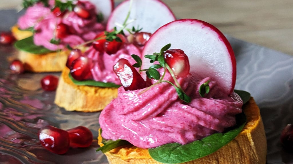 Das Rote-Bete-Frischkäse-Türmchen bildet einen schönen Farbkontrast zur gebackenen orangegelben Süßkartoffelscheibe.