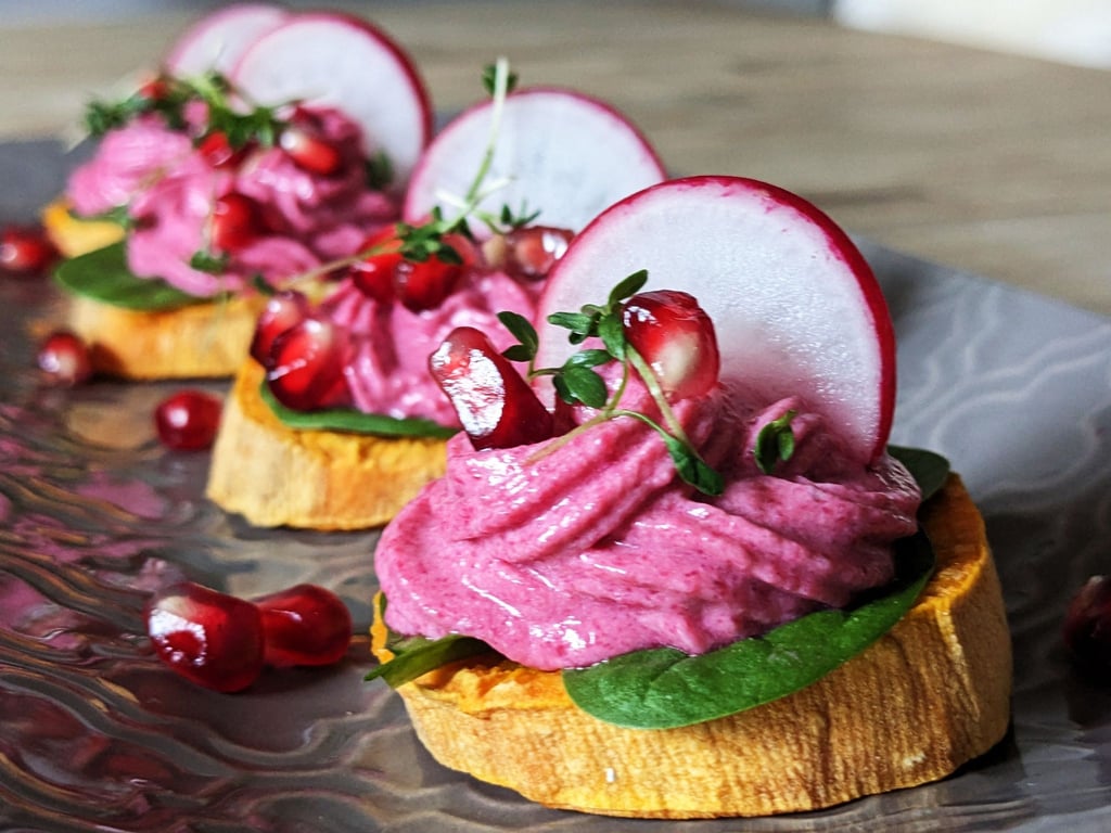Das Rote-Bete-Frischkäse-Türmchen bildet einen schönen Farbkontrast zur gebackenen orangegelben Süßkartoffelscheibe.