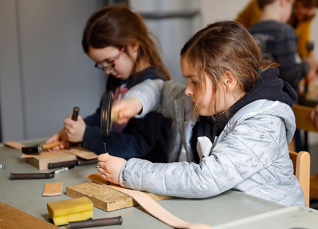 In der Ferienwerkstatt des Landesmuseums können Kinder selbst aktiv werden. Hier entstehen Gürtel, die mit Prägestempeln verziert werden.