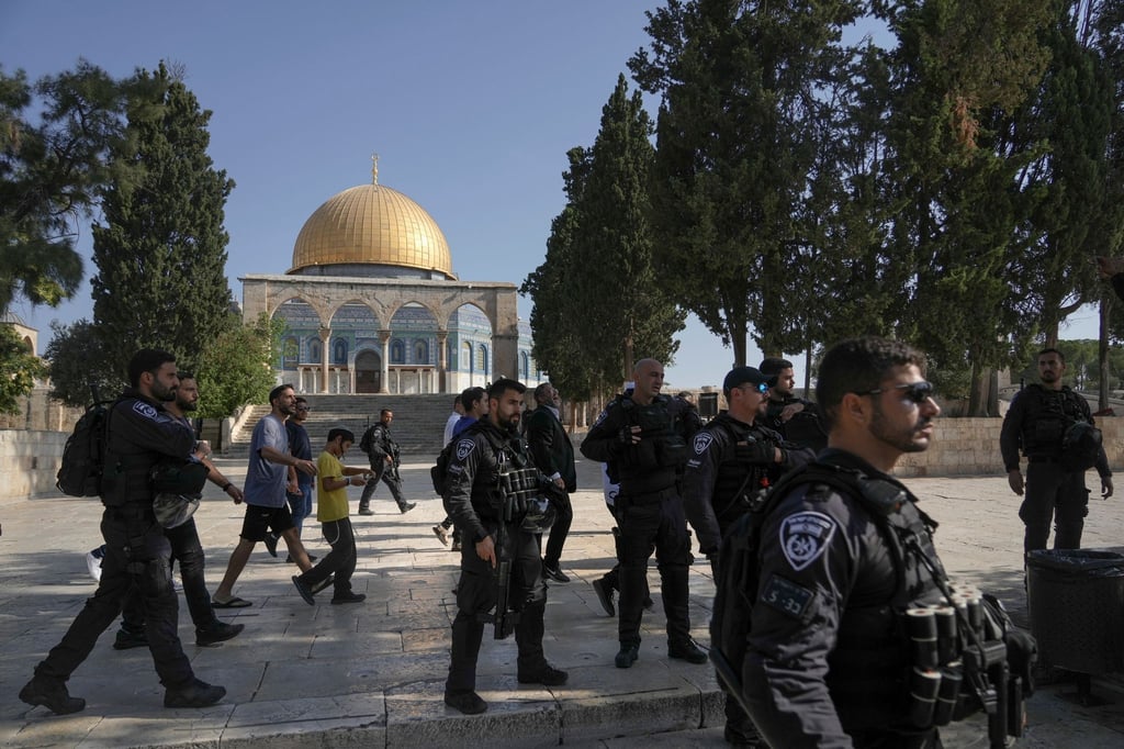Israelische Polizisten eskortieren eine Gruppe jüdischer Männer zum Tempelberg in der Altstadt von Jerusalem - im Hintergrund die Al-Aqsa-Moschee.