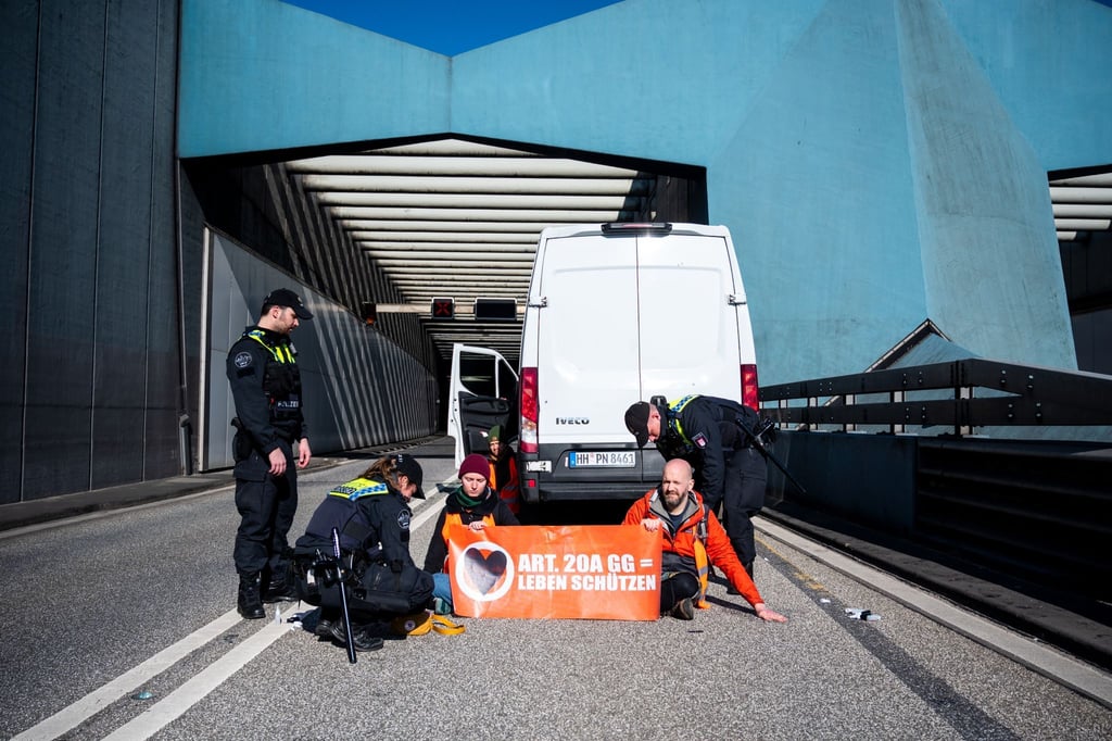 Klimaaktivisten haben sich auf der Fahrbahn der A7 festgeklebt.