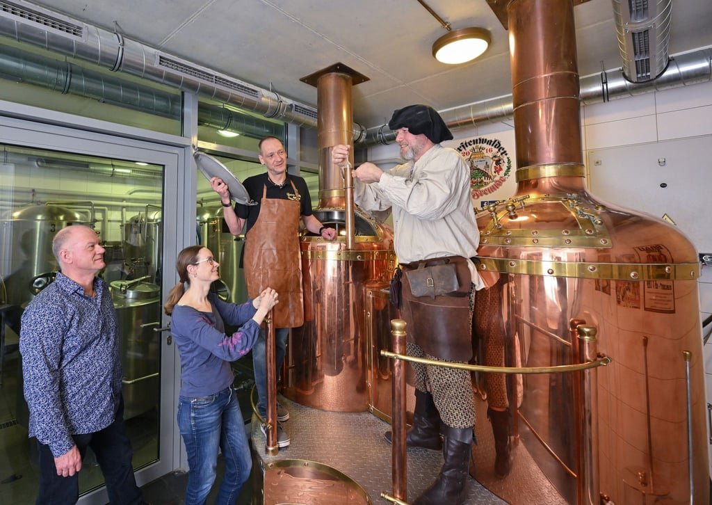 Am Sudkessel der Rathausbrauerei im alten Rathaus nehmen Holger Roger Pelz (l-r) von den Fürstenwalder Brau-Freunden und Katrin Riegel vom Tourismusverband zusammen mit Oliver Wittkopf und Bernd Norkeweit an einem Braukurs teil.