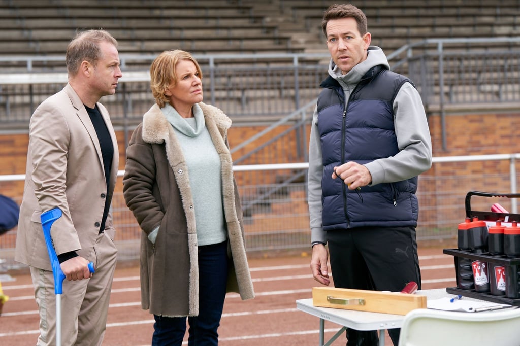 Marie Brand (Mariele Millowitsch) und Jürgen Simmel (Hinnerk Schönemann, l) befragen den Sporttrainer Victor Holtmann (Florian Anderer).